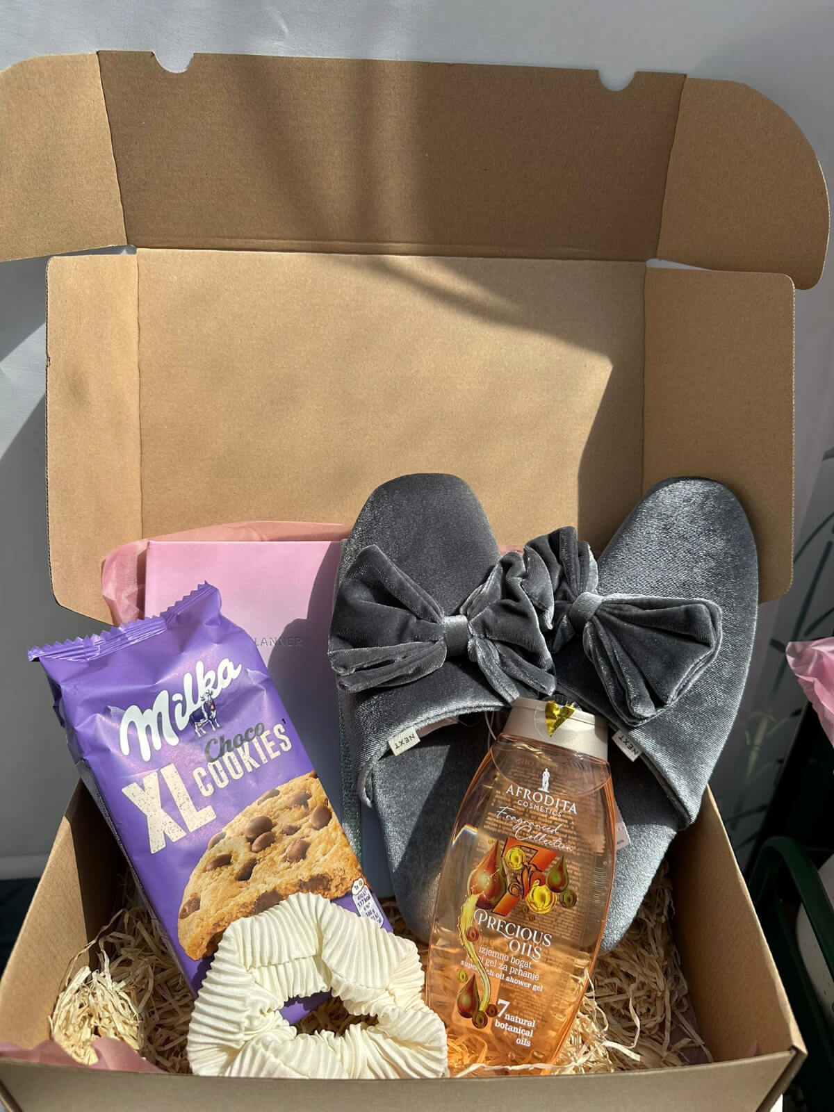 Afrodita skincare products and cozy slippers gift box for pampering and comfort.