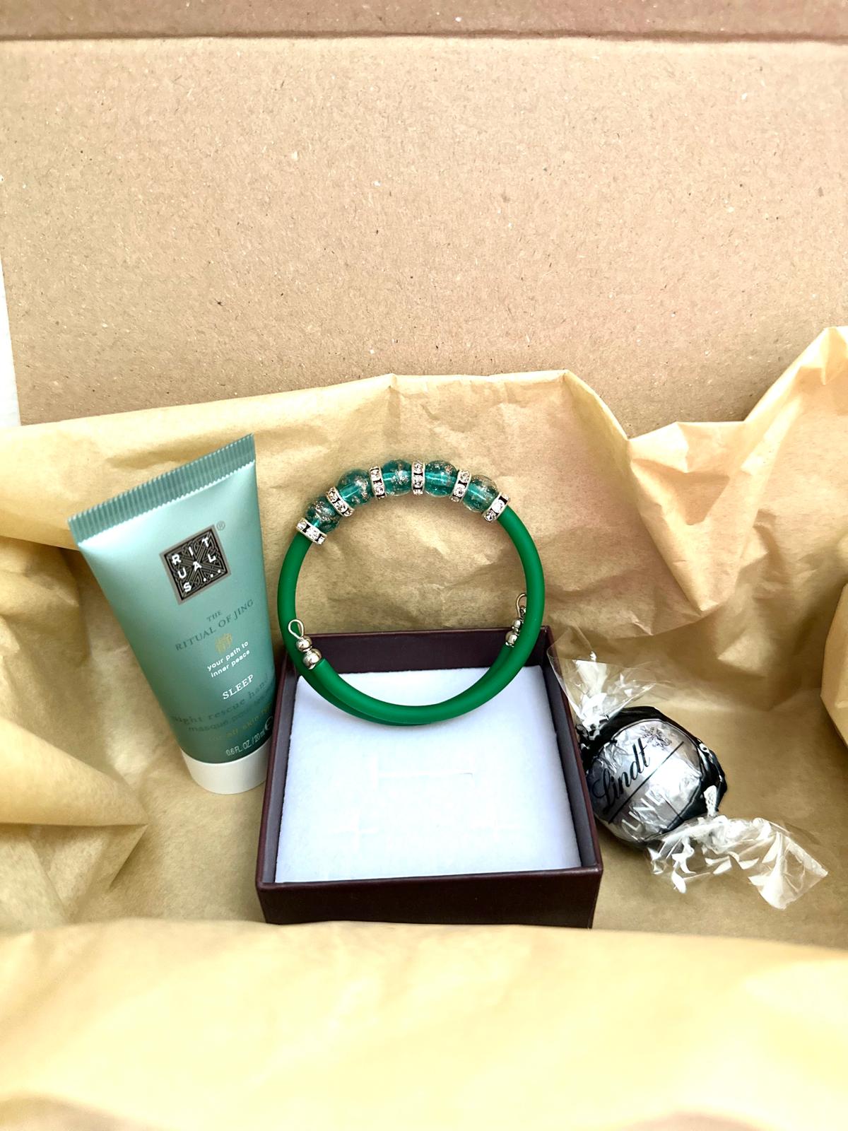 Green jewelry and Rituals cream set for stylish accessories and luxurious skincare care.