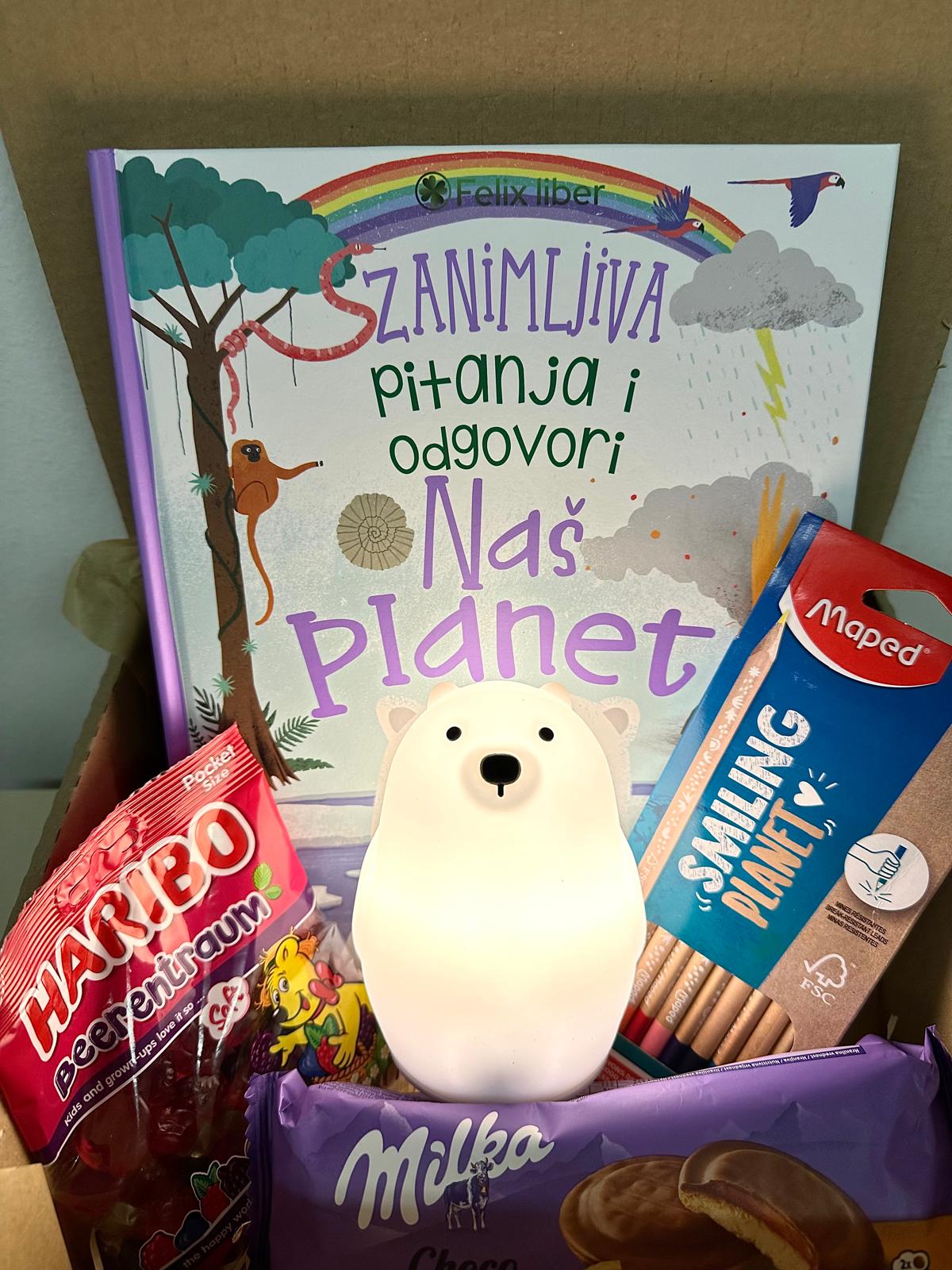 Gift box with "Naš planet" book and soft decorative light, inspiring creativity and learning.